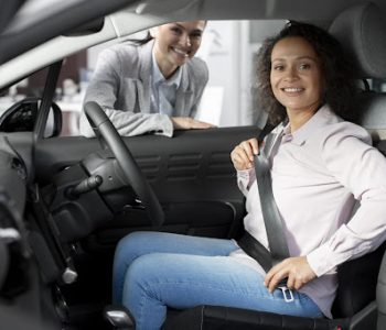 a young woman comparing the experience of buying a new car versus a used car, looking thoughtful inside a modern vehicle