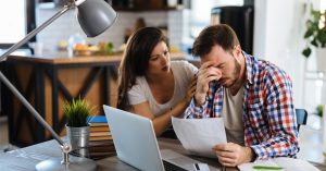 Young couple reviewing bills and finances while considering an income-based car lease option