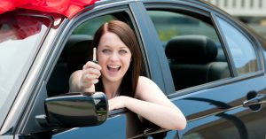 Happy driver holding car keys after completing the lease-to-own car approval process and receiving a vehicle.