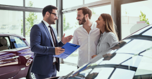 How Does Car Leasing Work in Australia? A couple discusses vehicle leasing options with a car consultant.
