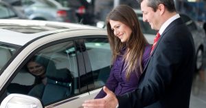 Customer comparing a vehicle with a representative at a car leasing company.
