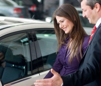Customer comparing a vehicle with a representative at a car leasing company.