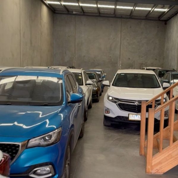 Car leasing in Melbourne with multiple vehicles displayed inside a spacious indoor car showroom.